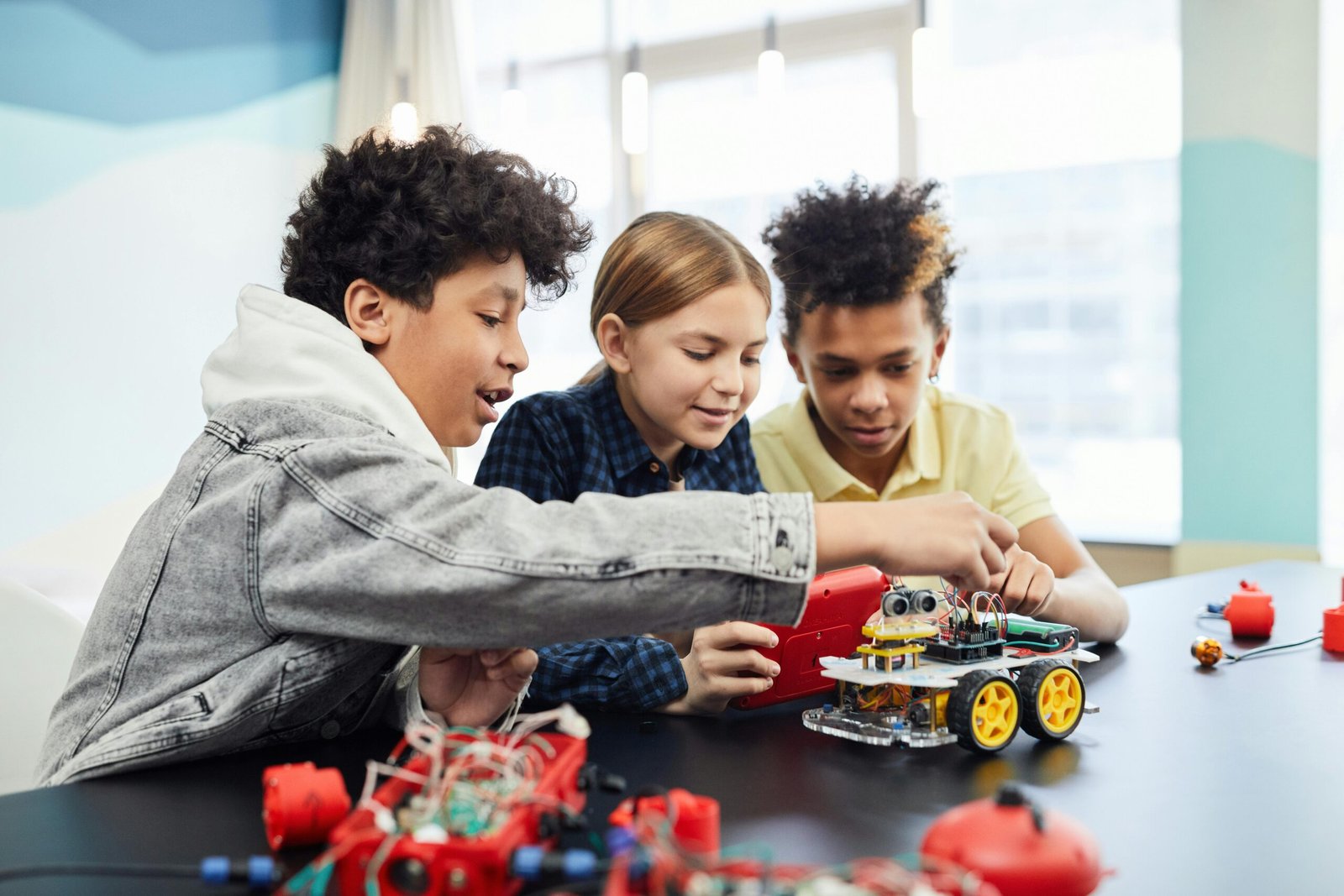 Children collaborating on an electronic robotics project, fostering teamwork and innovation.